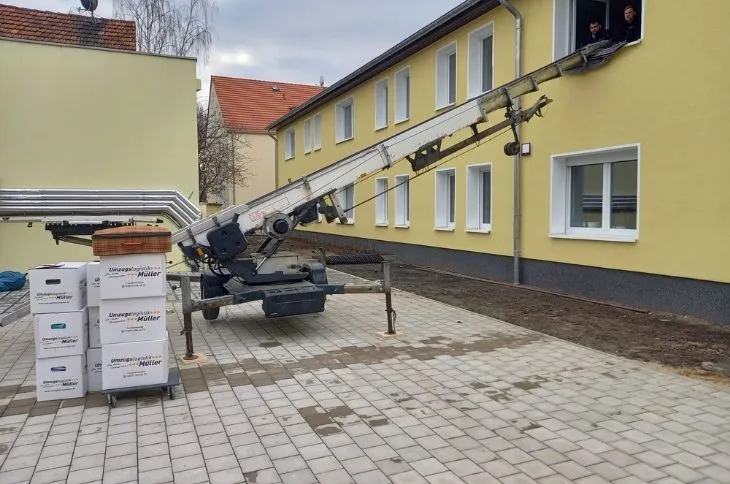 moebellift vor mehrfamilienhaus mit umzugskartons